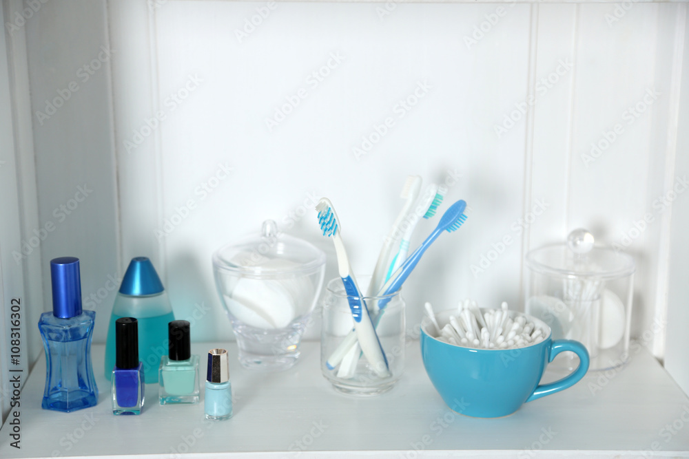 Bathroom set with toothbrushes and sponges on a shelf in light interior Bathroom set with toothbrushes and sponges on a shelf in light interior