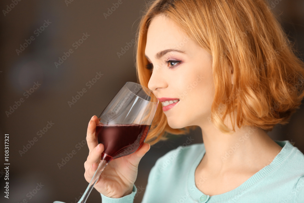 Young woman with glass of red wine on light blurred background Young woman with glass of red wine on light blurred background