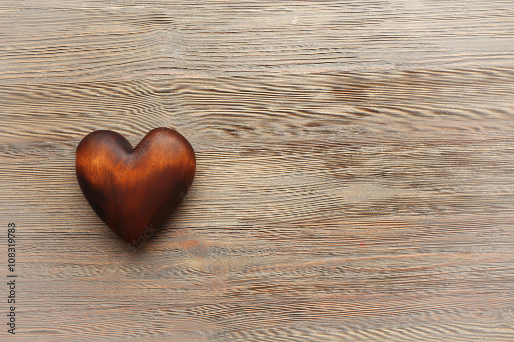 Obraz premium Brown heart on wooden background