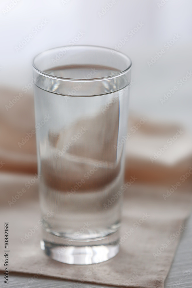 Glass of water with napkin on wooden background Glass of water with napkin on wooden background