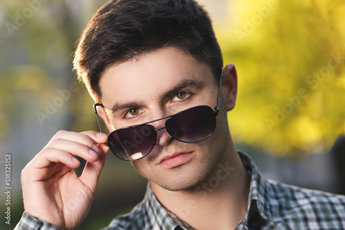 Closeup portrait of handsome young man with sunglasses