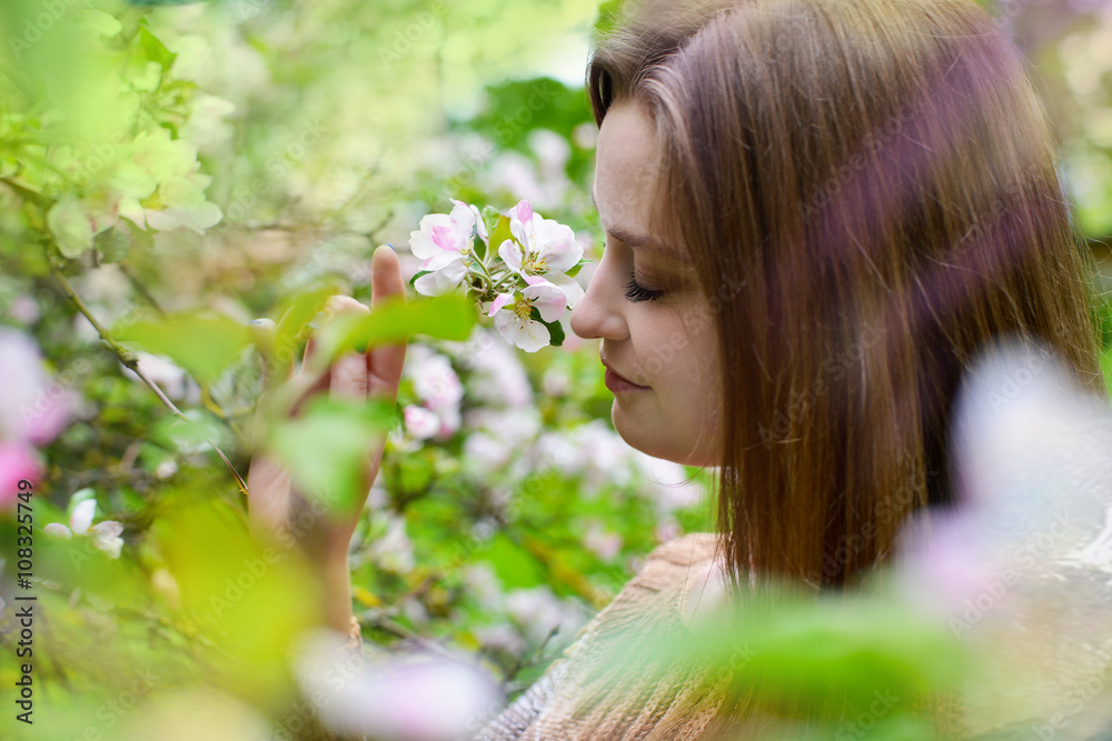 Woman in spring garden, inhaling the scent of flowers Woman in spring garden, inhaling the scent of flowers