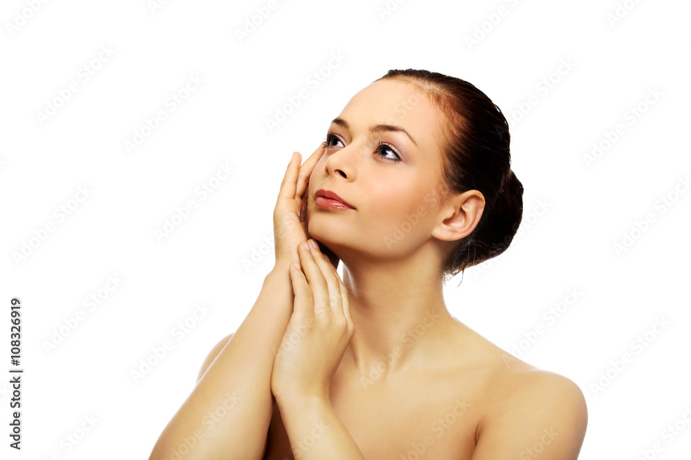 Beautiful young woman touching her face Beautiful young woman touching her face