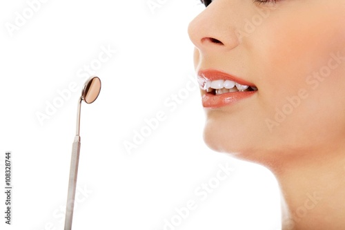 Young woman teeth and a dentist mouth mirror