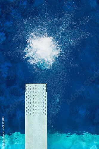 Springboard diving. Splash from a diver on the water surface. Shot from above