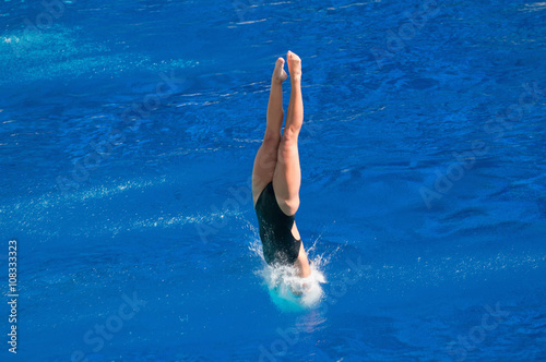 Breaking the surface. Female diving champion entering the water with minimum splash