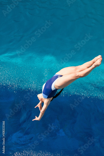 Female diving. Lady diver in the air above the swimming pool