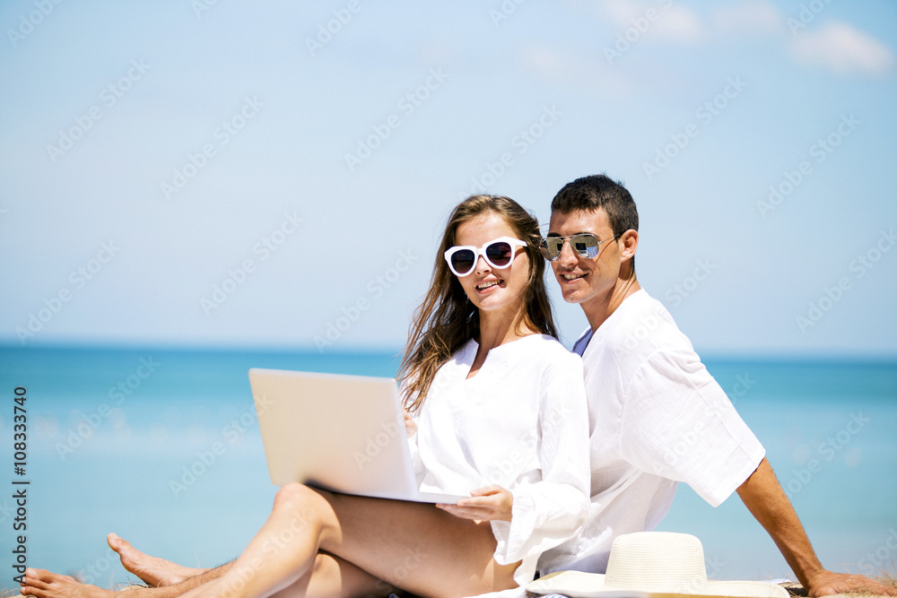 Summer couple using laptop