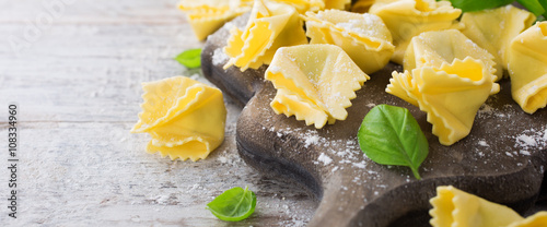 Homemade raw Italian saccottini with green pesto photo