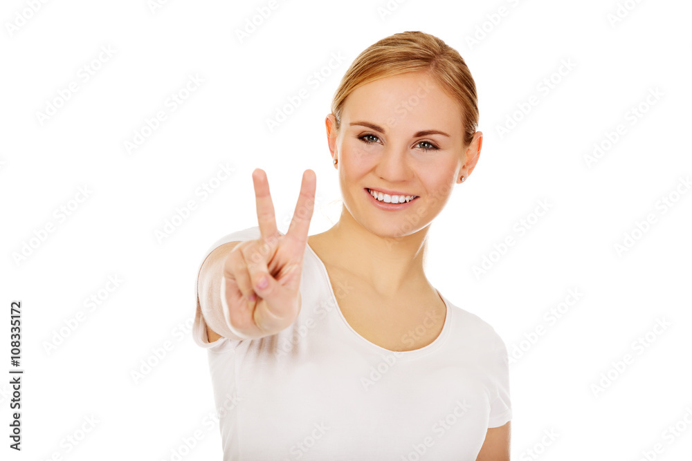 Smiling young woman showing the victory sign Smiling young woman showing the victory sign