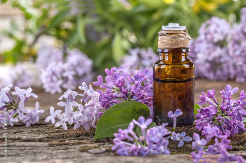 Essential oil made from lilac on a rustic table