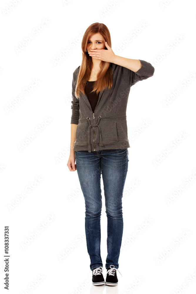 Teen woman covering her mouth with hand Teen woman covering her mouth with hand