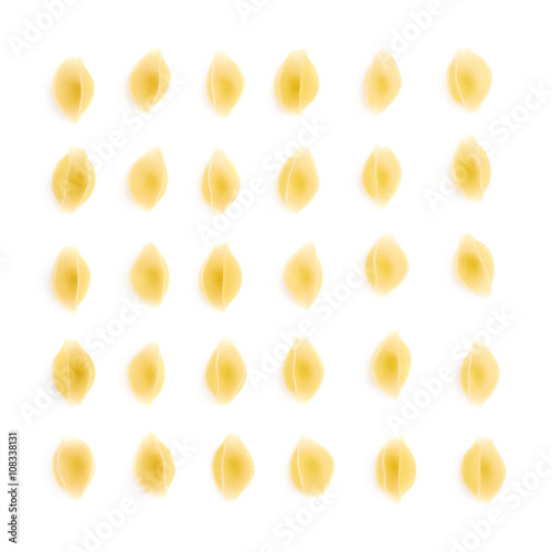 Single pieces of dry conchiglie pasta over isolated white background