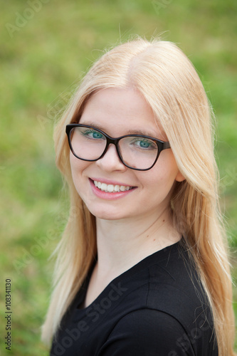 Young blonde girl with glasses smiling