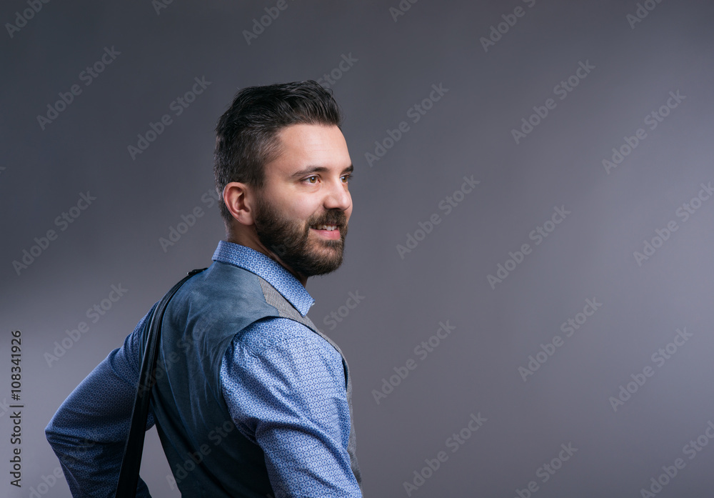 Hipster businessman in blue shirt, studio shot, gray background Hipster businessman in blue shirt, studio shot, gray background