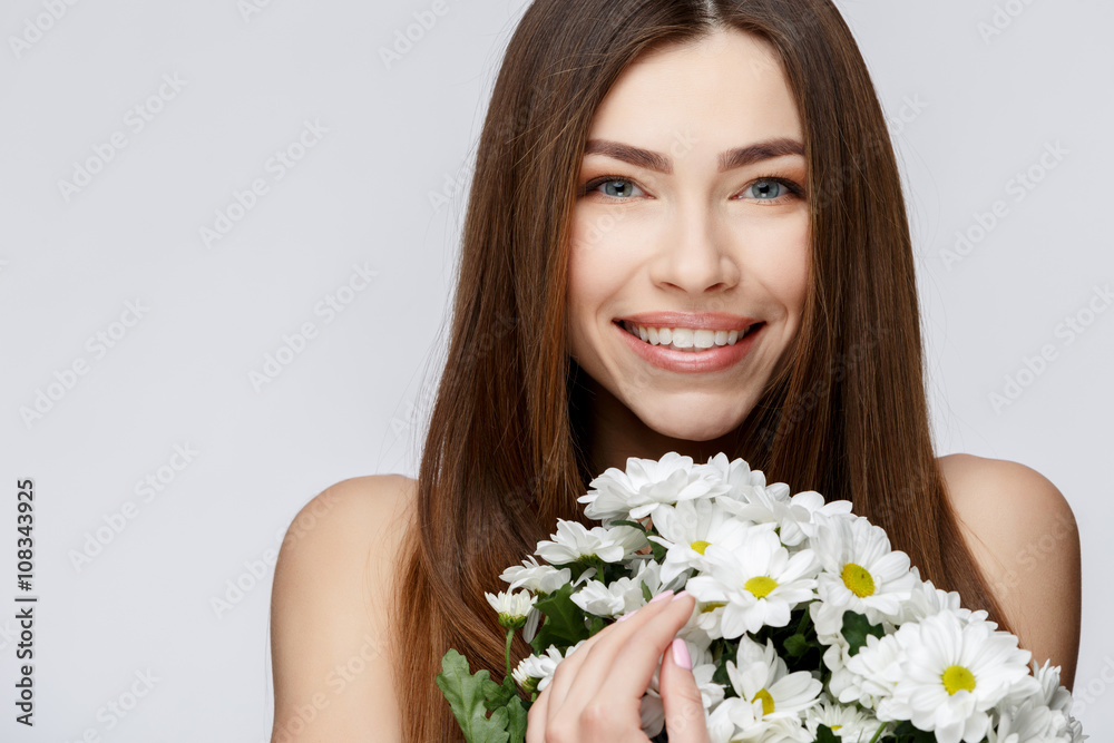 Beautiful Woman with Clean Fresh Skin holding flowers