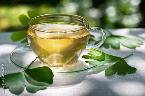 glass of herbaceous tea with ginkgo leaves