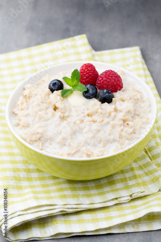 Oatmeal porridge in bowl with berries raspberries and blackberri