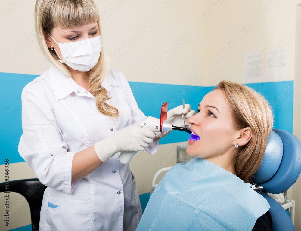 The reception was at the female dentist. Doctor examines the oral cavity on tooth decay. Caries protection. Tooth decay treatment. Female patient at dentist office curing teeth