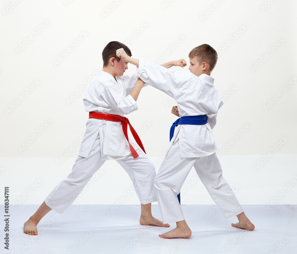 On a white background athletes train blocks and kicks of karate