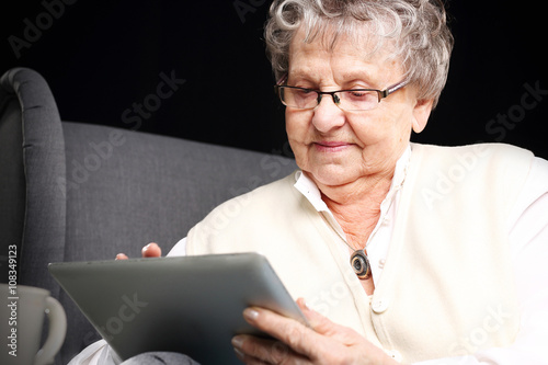 Starsza kobieta z tabletem.Starsza kobieta serfuje po internecie.