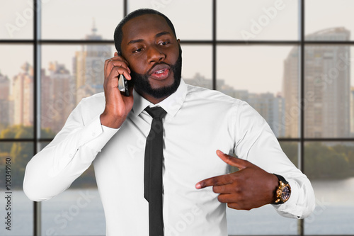 Darkskinned man on the phone. Manager's phonetalk in the city. Diplomacy is priceless. Honest and trustworthy leader. photo