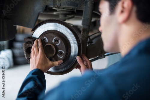 Mechanic examining car brake photo