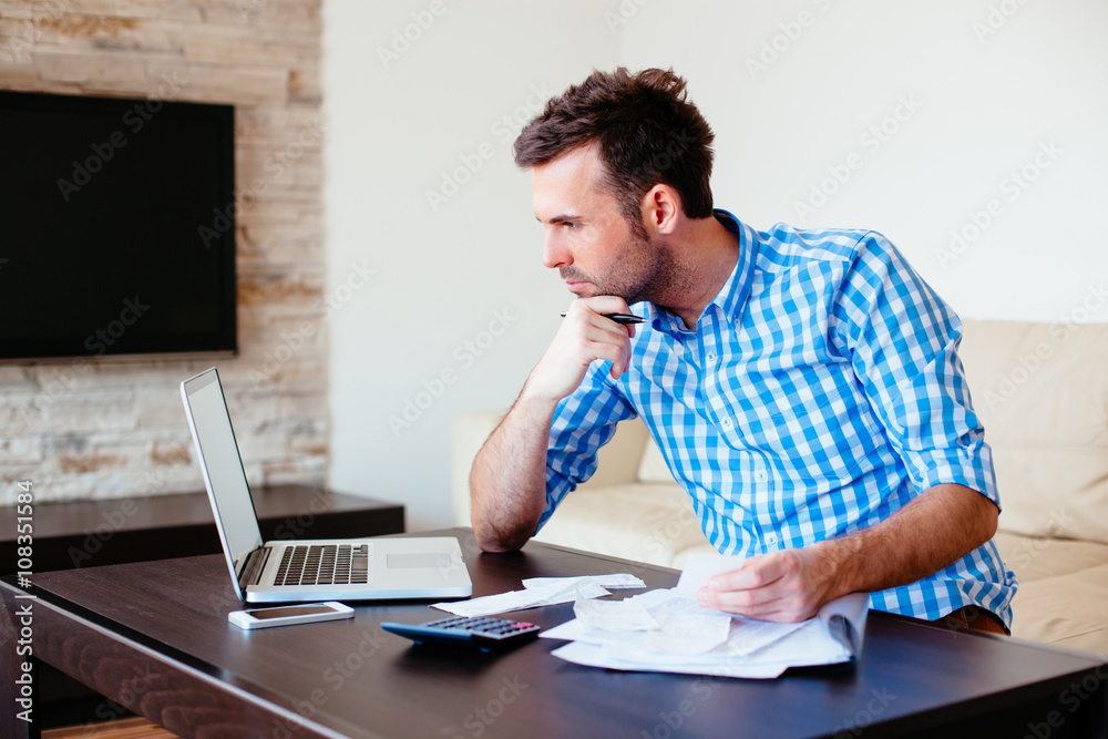 Stressed young man counting home finance Stressed young man counting home finance