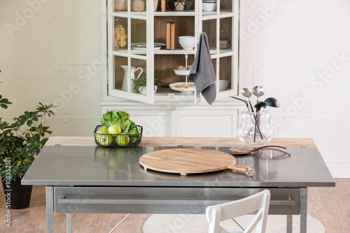 empty cutting board behind kitchen cupboard with metal kitchen countertop modern kitchen photo