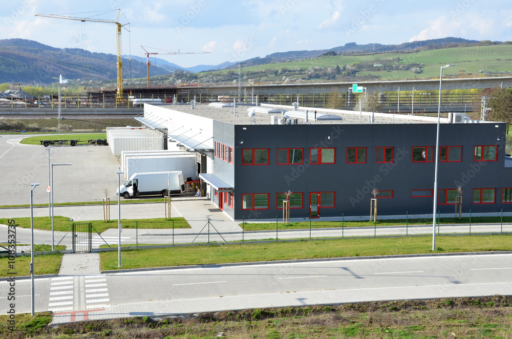 Logistics center, freight is uncharged from van. Tower cranes in background Logistics center, freight is uncharged from van. Tower cranes in background