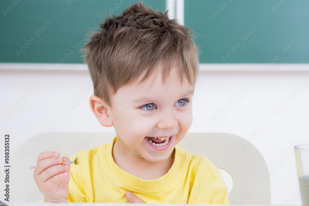 Naklejka premium lachender kleiner junge beim malen mit dem pinsel