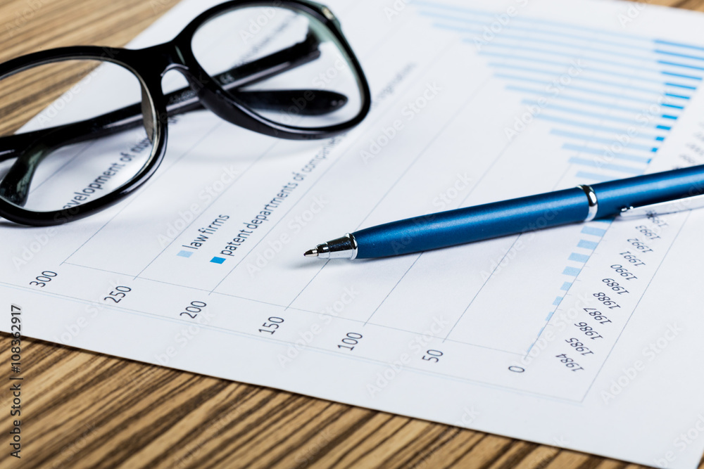 Financial paper charts and graphs on the table. Financial paper charts and graphs on the table.
