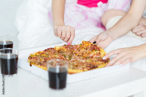 friends or teen girls eating pizza at home © Syda Productions