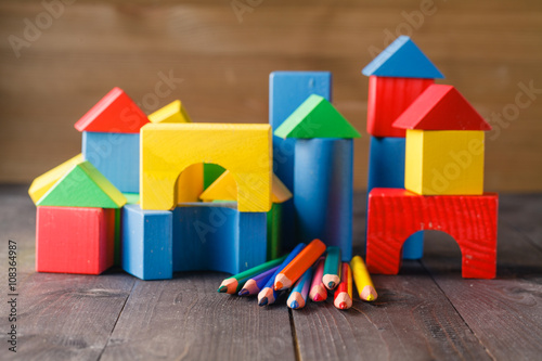 Different colors of pencils ontable with building blocks photo