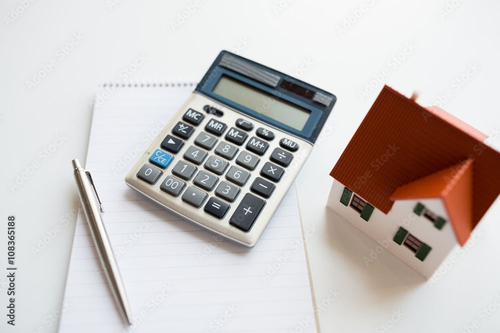 close up of home model, calculator and notebook close up of home model, calculator and notebook