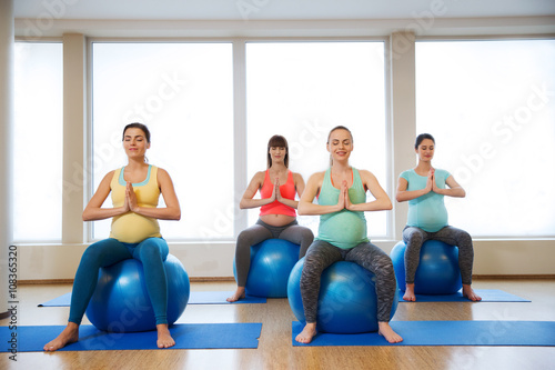 happy pregnant women exercising on fitball in gym