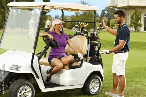 Happy golfers talking in golf cart