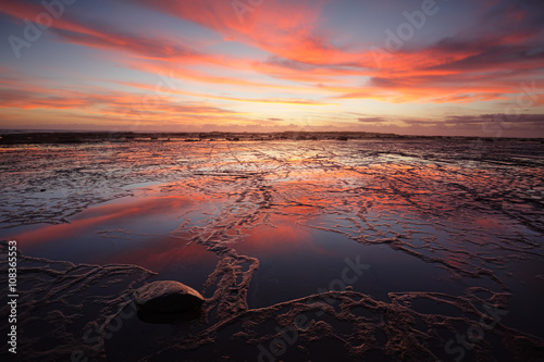 Sunrise over Long Reef at low tide with reflectins photo