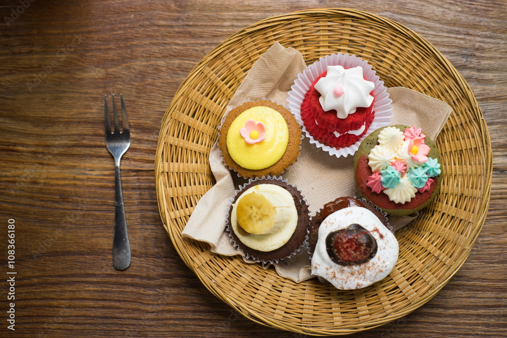 Mixed cupcakes on wood table.