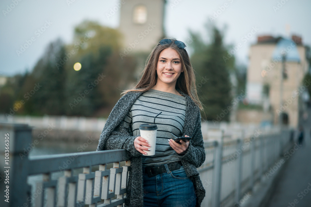 girl walking with coffee and phone