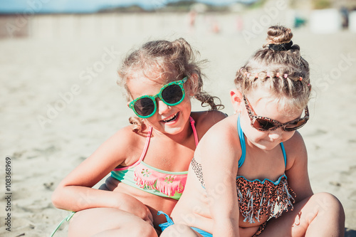 girlfriends to sunbathe by the sea
