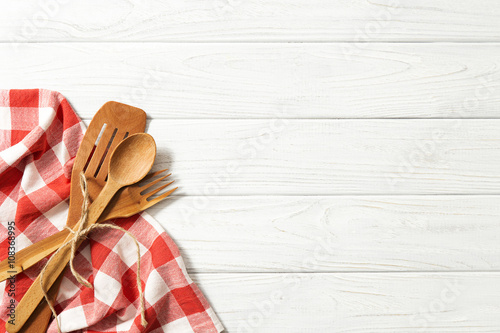 Wooden spoons and other cooking tools with  napkin on the kitchen table.