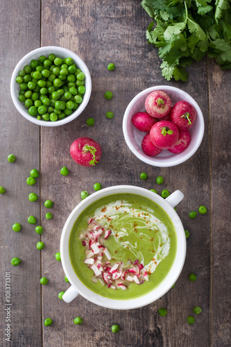 Pea cream with radishes on a rustic wooden background 