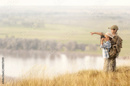 Children with tourists on a cliff at sunset