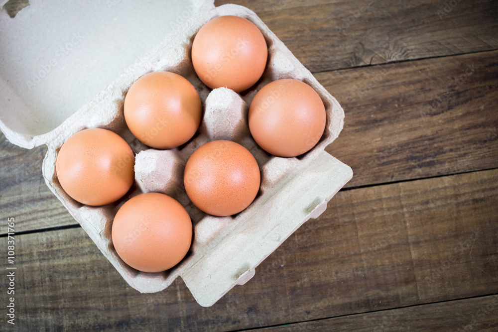 Eggs in paper tray on wood background Eggs in paper tray on wood background
