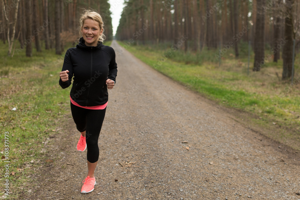 Sportliche Junge Frau Joggt Auf Einem Schotterweg Im Wald Stock-Foto ...