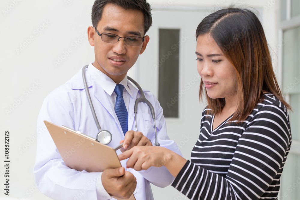 Doctor holding application form while consulting patient Doctor holding application form while consulting patient