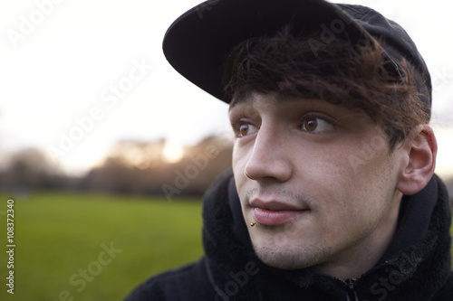 Head And Shoulders Portrait Of Young Man Walking In Park