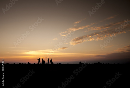 man and woman photographer taking photo on sunset mountain peak © peckyhyong