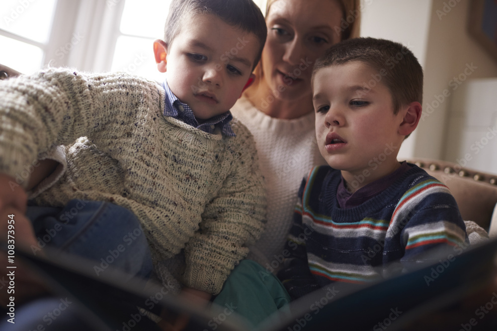 Mother Sitting In Chair At Home Reading Story To Sons Mother Sitting In Chair At Home Reading Story To Sons